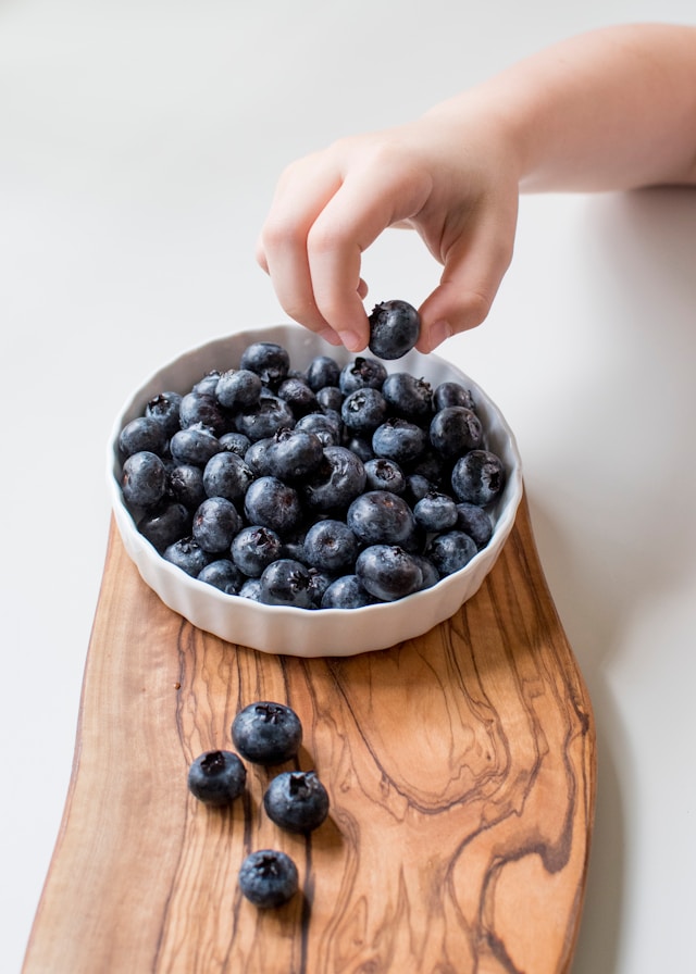 Premium olive wood board with blueberries